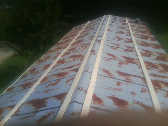 Rusted metal roof panels with new wood purlins before replacement — Storm Damage Roof Repair in Virginia City by Roofing Brothers